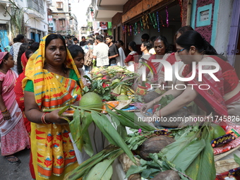 A devotee collects free religious material to perform prayers ahead of the Hindu religious festival of Chhat Puja in Kolkata, India, on Nove...