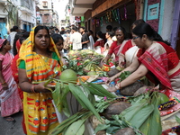 A devotee collects free religious material to perform prayers ahead of the Hindu religious festival of Chhat Puja in Kolkata, India, on Nove...