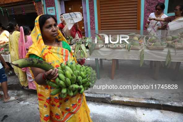 A devotee collects free religious material to perform prayers ahead of the Hindu religious festival of Chhat Puja in Kolkata, India, on Nove...