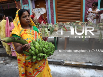 A devotee collects free religious material to perform prayers ahead of the Hindu religious festival of Chhat Puja in Kolkata, India, on Nove...