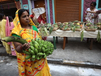 A devotee collects free religious material to perform prayers ahead of the Hindu religious festival of Chhat Puja in Kolkata, India, on Nove...