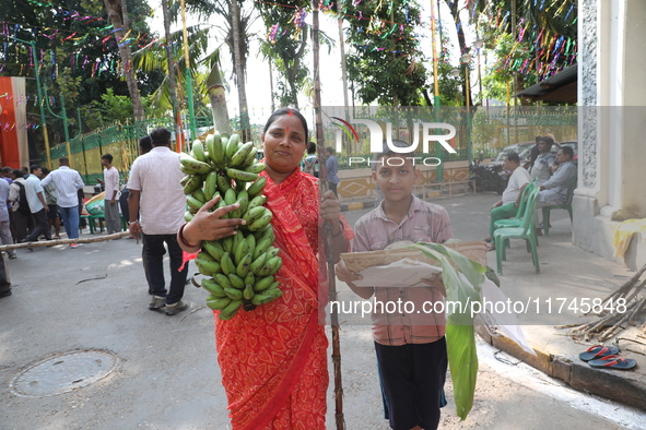 A devotee collects free religious material to perform prayers ahead of the Hindu religious festival of Chhat Puja in Kolkata, India, on Nove...