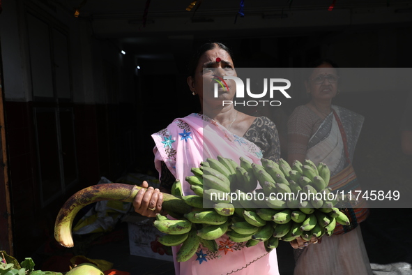 A devotee collects free religious material to perform prayers ahead of the Hindu religious festival of Chhat Puja in Kolkata, India, on Nove...