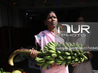 A devotee collects free religious material to perform prayers ahead of the Hindu religious festival of Chhat Puja in Kolkata, India, on Nove...