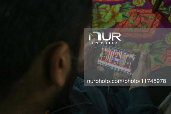 A man watches a live telecast of a speech by former US President and Republican presidential candidate Donald Trump on his mobile phone in S...