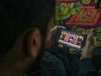 A man watches a live telecast of a speech by former US President and Republican presidential candidate Donald Trump on his mobile phone in S...