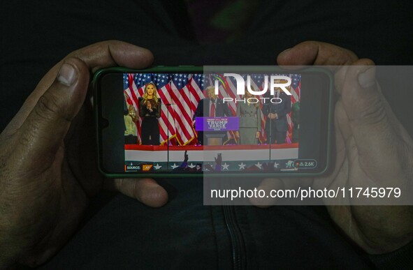 A man watches a live telecast of a speech by former US President and Republican presidential candidate Donald Trump on his mobile phone in S...