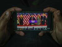 A man watches a live telecast of a speech by former US President and Republican presidential candidate Donald Trump on his mobile phone in S...