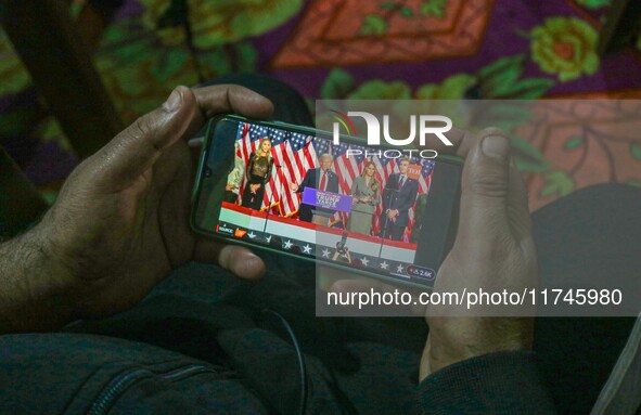 A man watches a live telecast of a speech by former US President and Republican presidential candidate Donald Trump on his mobile phone in S...