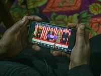 A man watches a live telecast of a speech by former US President and Republican presidential candidate Donald Trump on his mobile phone in S...