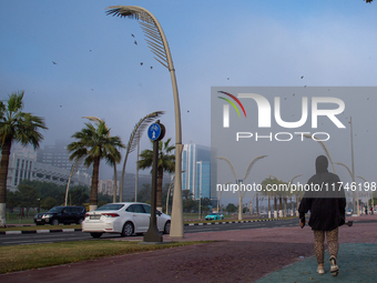 People walk along the Doha Corniche in heavy fog in Doha, Qatar, on November 6, 2024. (