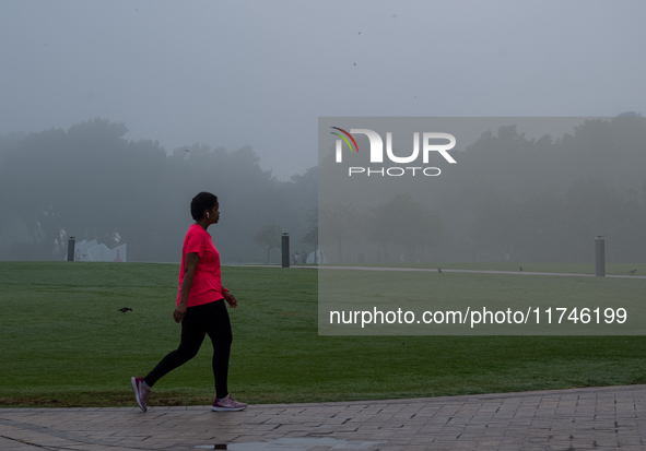 People walk along the Doha Corniche in heavy fog in Doha, Qatar, on November 6, 2024. 