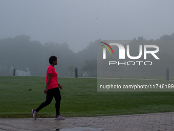 People walk along the Doha Corniche in heavy fog in Doha, Qatar, on November 6, 2024. (