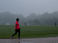 People walk along the Doha Corniche in heavy fog in Doha, Qatar, on November 6, 2024. (