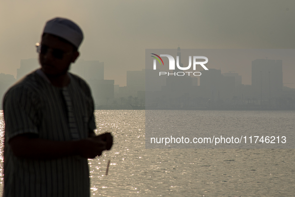 People walk along the Doha Corniche in heavy fog in Doha, Qatar, on November 6, 2024. 