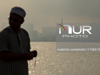 People walk along the Doha Corniche in heavy fog in Doha, Qatar, on November 6, 2024. (