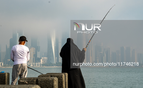 People fish at the Doha Corniche in heavy fog in Doha, Qatar, on November 6, 2024. 