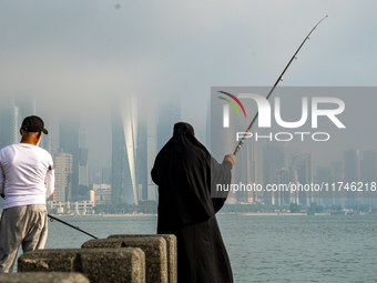 People fish at the Doha Corniche in heavy fog in Doha, Qatar, on November 6, 2024. (