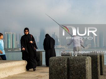 People fish at the Doha Corniche in heavy fog in Doha, Qatar, on November 6, 2024. (