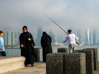 People fish at the Doha Corniche in heavy fog in Doha, Qatar, on November 6, 2024. (