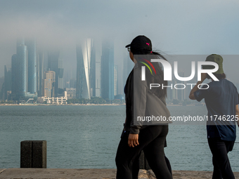 People walk along the Doha Corniche in heavy fog in Doha, Qatar, on November 6, 2024. (