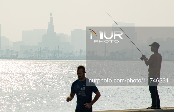 People fish at the Doha Corniche in heavy fog in Doha, Qatar, on November 6, 2024. 