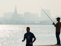 People fish at the Doha Corniche in heavy fog in Doha, Qatar, on November 6, 2024. (