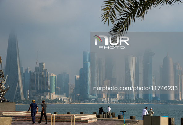 People walk along the Doha Corniche in heavy fog in Doha, Qatar, on November 6, 2024. 