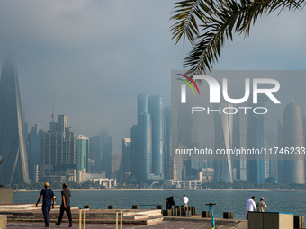 People walk along the Doha Corniche in heavy fog in Doha, Qatar, on November 6, 2024. (