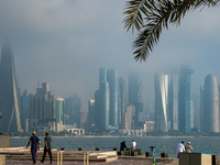 People walk along the Doha Corniche in heavy fog in Doha, Qatar, on November 6, 2024. (