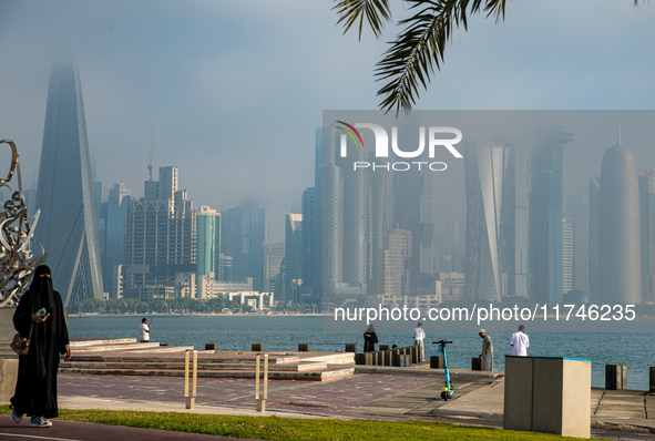 People walk along the Doha Corniche in heavy fog in Doha, Qatar, on November 6, 2024. 