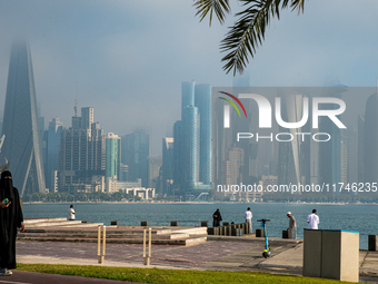 People walk along the Doha Corniche in heavy fog in Doha, Qatar, on November 6, 2024. (