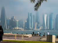 People walk along the Doha Corniche in heavy fog in Doha, Qatar, on November 6, 2024. (