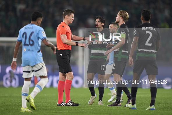 Referee Daniel Siebert and players of Sporting CP discuss during the UEFA Champions League match between Sporting CP and Manchester City at...