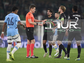 Referee Daniel Siebert and players of Sporting CP discuss during the UEFA Champions League match between Sporting CP and Manchester City at...