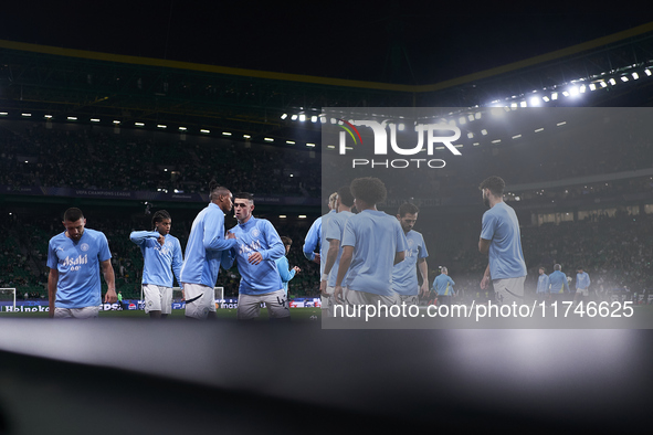 Players of Manchester City high-five each other during the warm-up before the UEFA Champions League match between Sporting CP and Manchester...