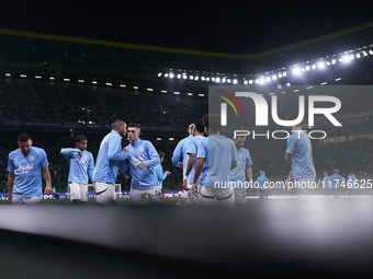 Players of Manchester City high-five each other during the warm-up before the UEFA Champions League match between Sporting CP and Manchester...