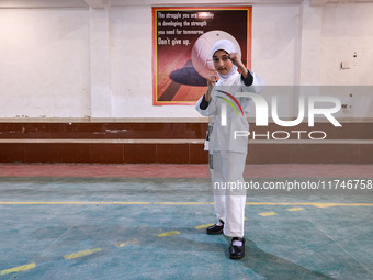 Sumaiya, a 9-year-old girl from Sopore, practices before her karate match at the indoor stadium in Baramulla, Jammu and Kashmir, India, on N...