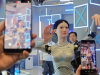 Visitors watch a humanoid robot ''Xiaohui'' perform a song and dance at the 7th CIIE in Shanghai, China, on November 6, 2024. (