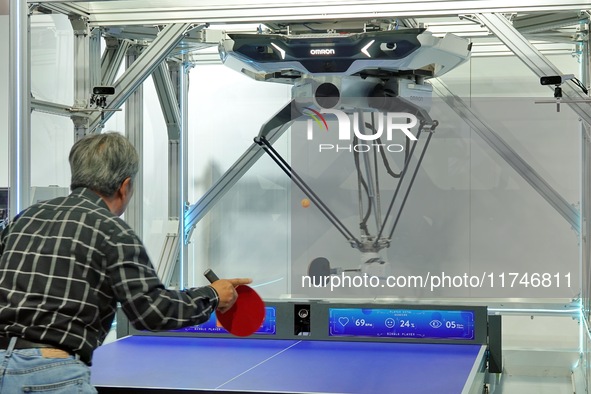 Visitors play ball with the Omron FORPHEUS table tennis coaching robot at the 7th CIIE in Shanghai, China, on November 6, 2024. 