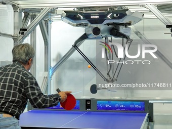 Visitors play ball with the Omron FORPHEUS table tennis coaching robot at the 7th CIIE in Shanghai, China, on November 6, 2024. (