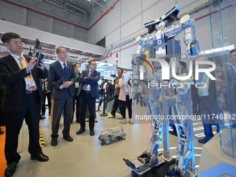 Visitors look at the Qiyuan ETH 01 humanoid composite exoskeleton robot at the 7th CIIE in Shanghai, China, on November 6, 2024. (