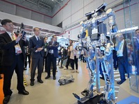 Visitors look at the Qiyuan ETH 01 humanoid composite exoskeleton robot at the 7th CIIE in Shanghai, China, on November 6, 2024. (