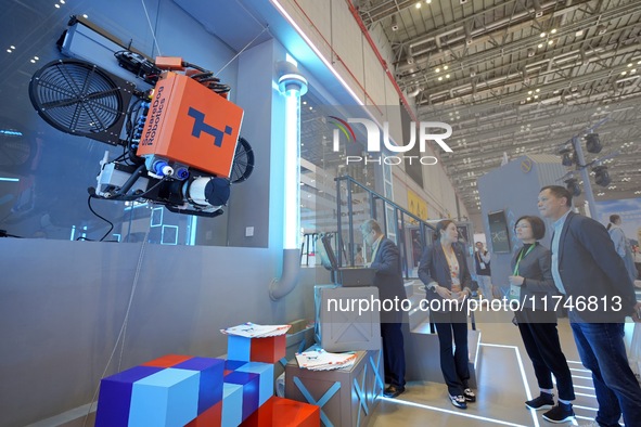 Visitors learn about exterior wall cleaning robots at the 7th CIEE in Shanghai, China, on November 6, 2024. 