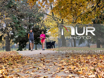 People wear shorts and walk in a park among colorful trees during the autumn season in Toronto, Ontario, Canada, on November 5, 2024. Toront...