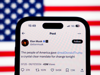 American flag displayed on a laptop screen and Elon Musk account on X displayed on a phone screen are seen in this illustration photo taken...