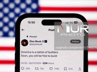 American flag displayed on a laptop screen and Elon Musk account on X displayed on a phone screen are seen in this illustration photo taken...