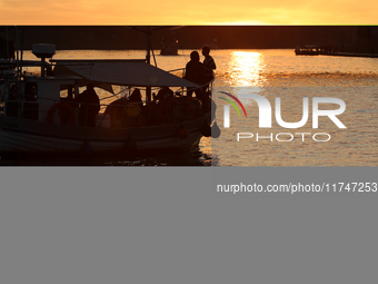 A boat floats on the Vistula River at sunset in Krakow, Poland, on October 27, 2024. (