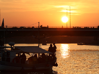 A boat floats on the Vistula River at sunset in Krakow, Poland, on October 27, 2024. (