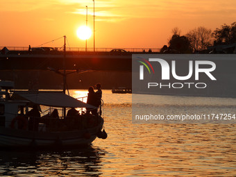 A boat floats on the Vistula River at sunset in Krakow, Poland, on October 27, 2024. (